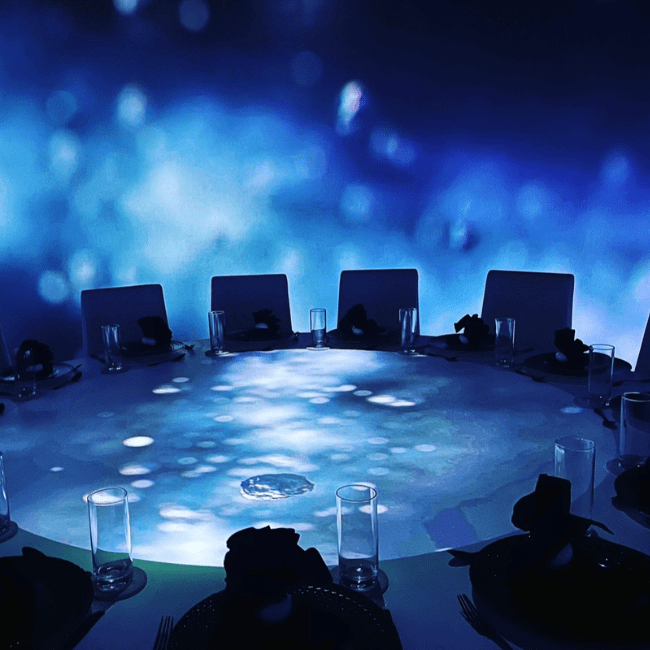 round table surrounded by dining seats in a low lit room